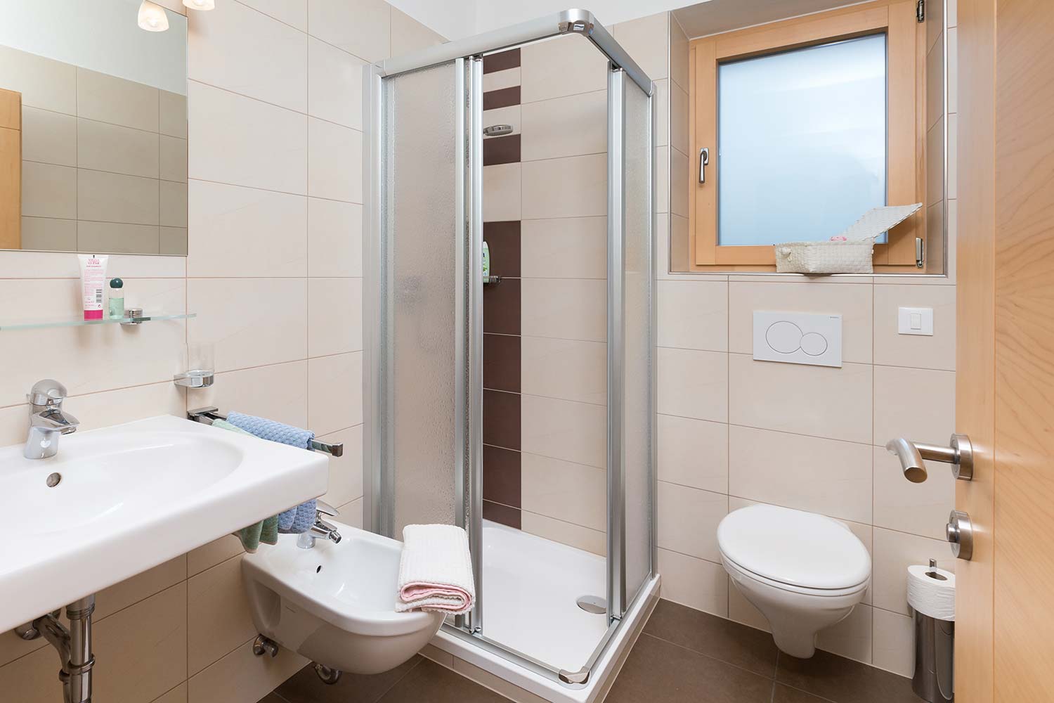 Bagno con doccia, finestra, WC e asciugacapelli